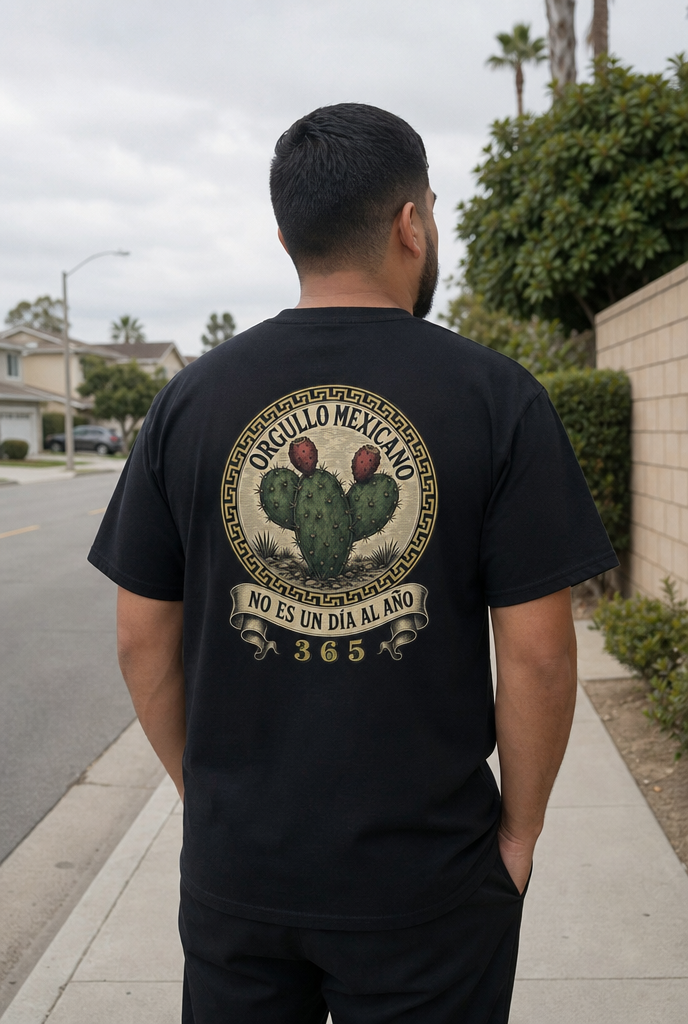 Man wearing the black Orgullo Mexicano tee, back print: nopal roundel, NO ES UN DÍA AL AÑO, 365