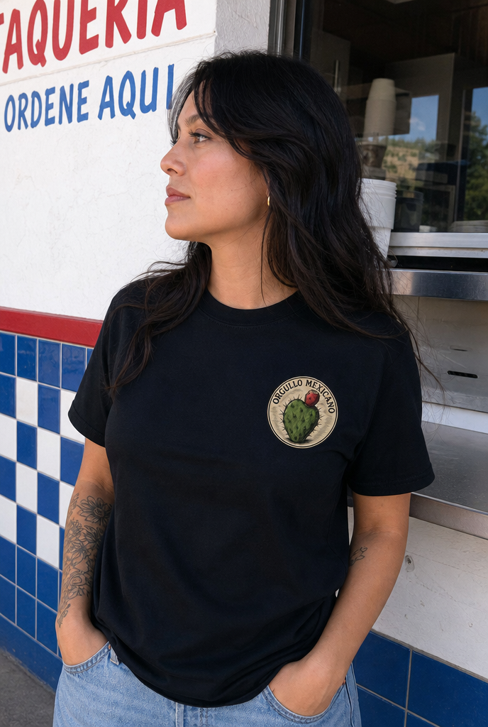Woman wearing the black Orgullo Mexicano tee, small nopal emblem on the left chest
